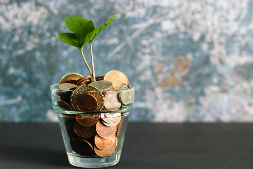 coins in a glass with a little tree growing out of it