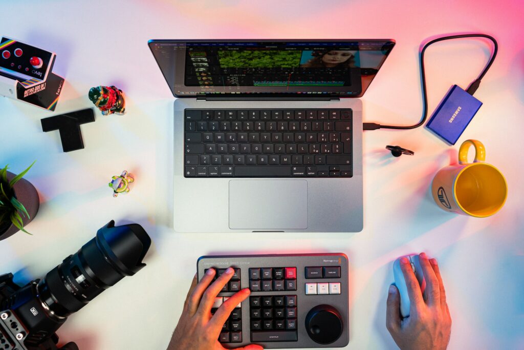 desk showing laptop, camera and keyboard